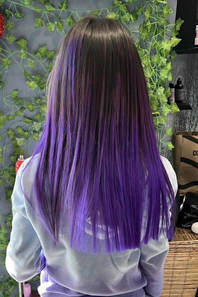 Purple dyed hair reflects Ayda Ghaffari's skill at hair coloring. The hair also has a blunt chop, demonstrating her technique.