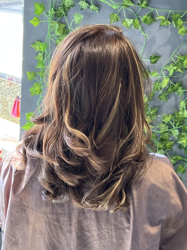 Highlighted hair reflects Ayda Ghaffari's skill at hair coloring and styling. The hair's layering reflects her attention to detail and skill.