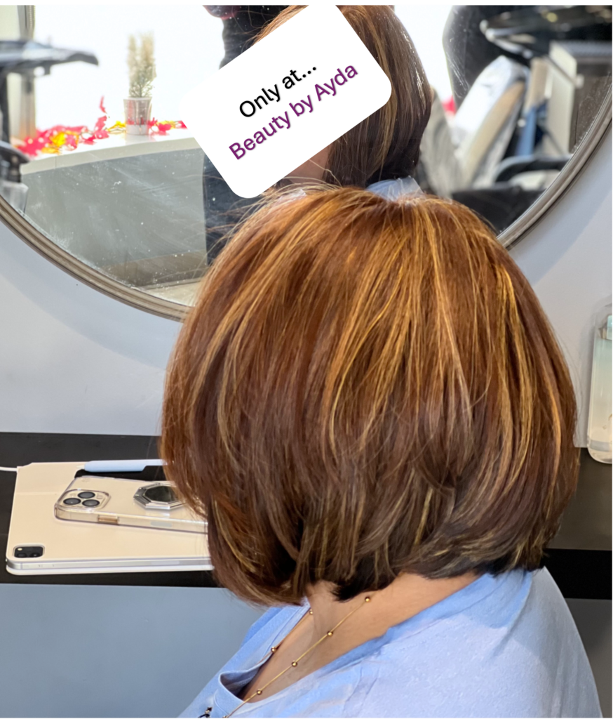 Highlighted hair in a bob reflects Ayda Ghaffari's skill at hair coloring, styling, and shaping. The hair's shorter length reflects her attention to detail and commitment to helping clients find the shape that fits their face best.